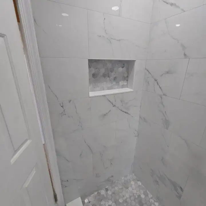 Recessed niche cut into large-format marble-look tile, edges mitred