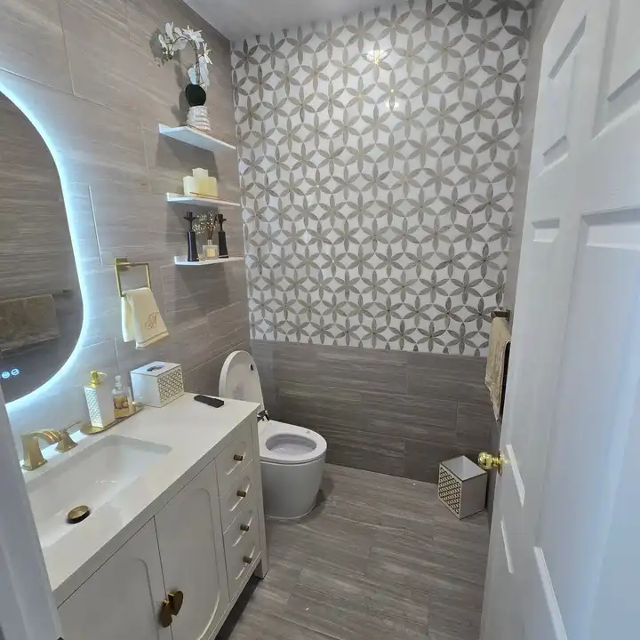 Feature wall in patterned tile behind a floating vanity with an LED mirror