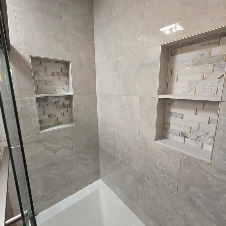 Two recessed niches with a stone mosaic back set into large-format wall tile