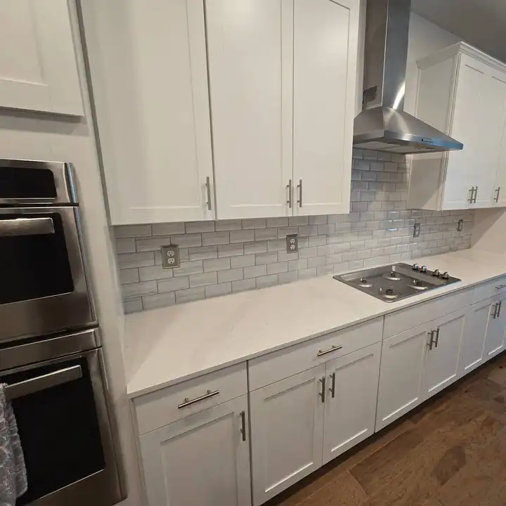 Grey subway backsplash continuing past a built-in double oven