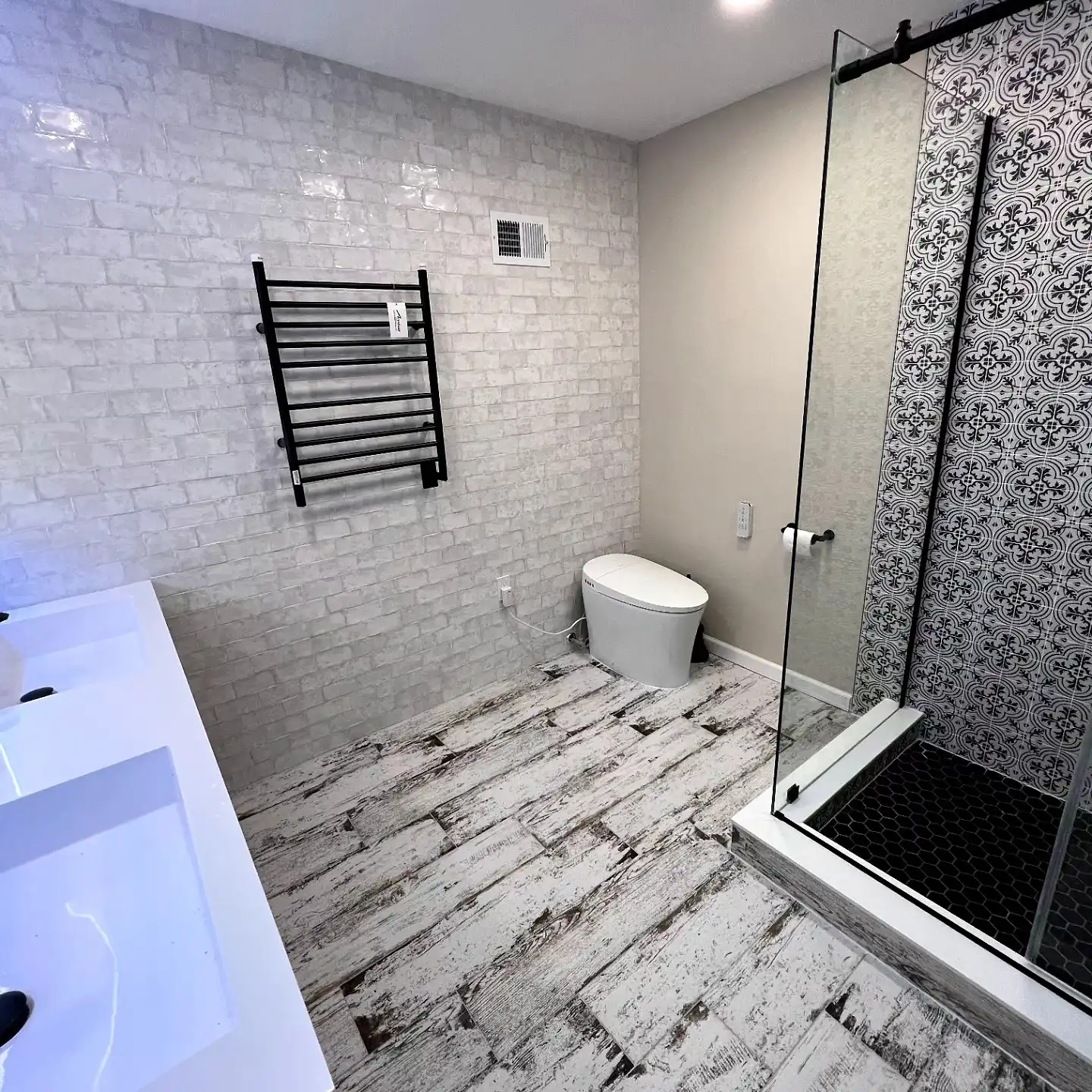 The same bathroom finished in white handmade-look tile with a patterned shower