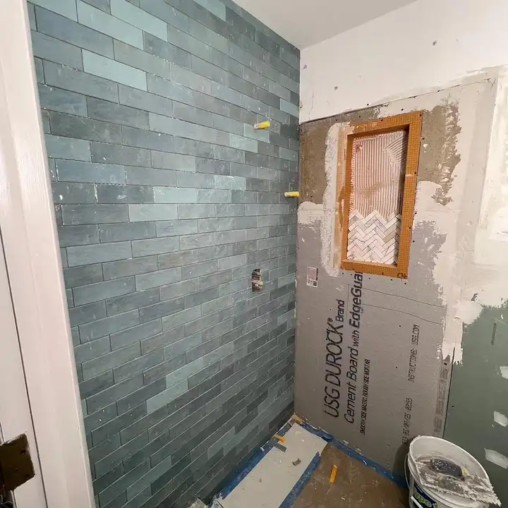 Green subway tile going up on fresh backer board, photographed for the homeowner