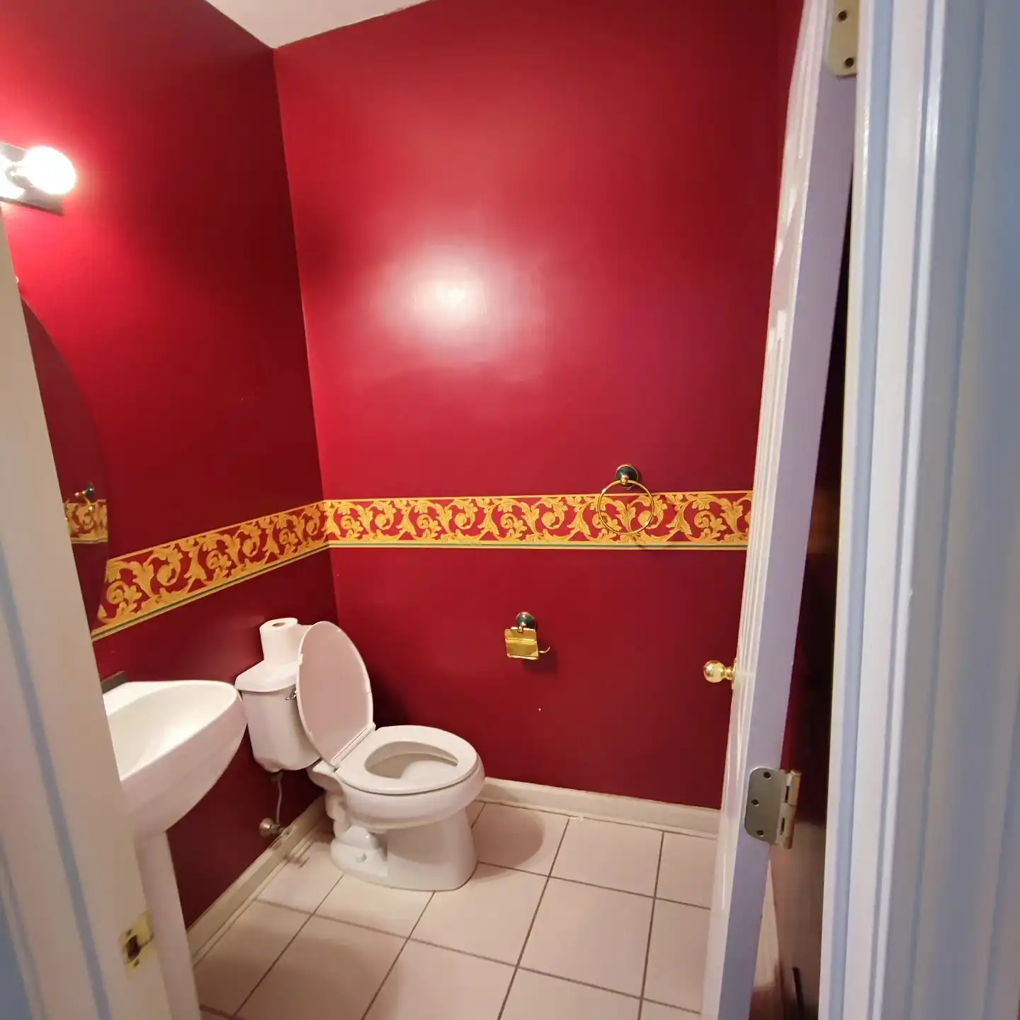 Original hall bathroom with red walls and a decorative border
