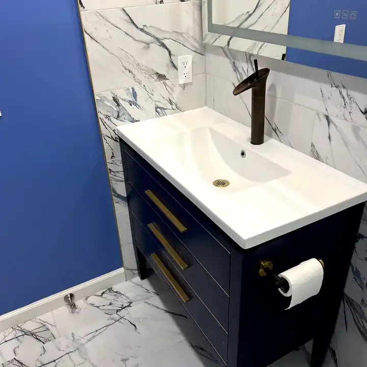 Navy vanity with a brushed gold faucet against a navy painted wall