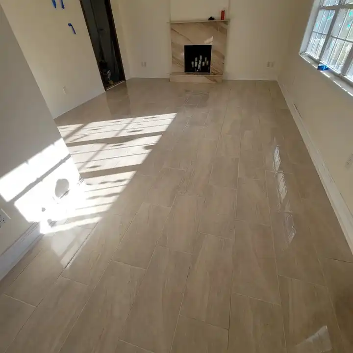 Sunlight across a wood-look plank tile floor toward a fireplace
